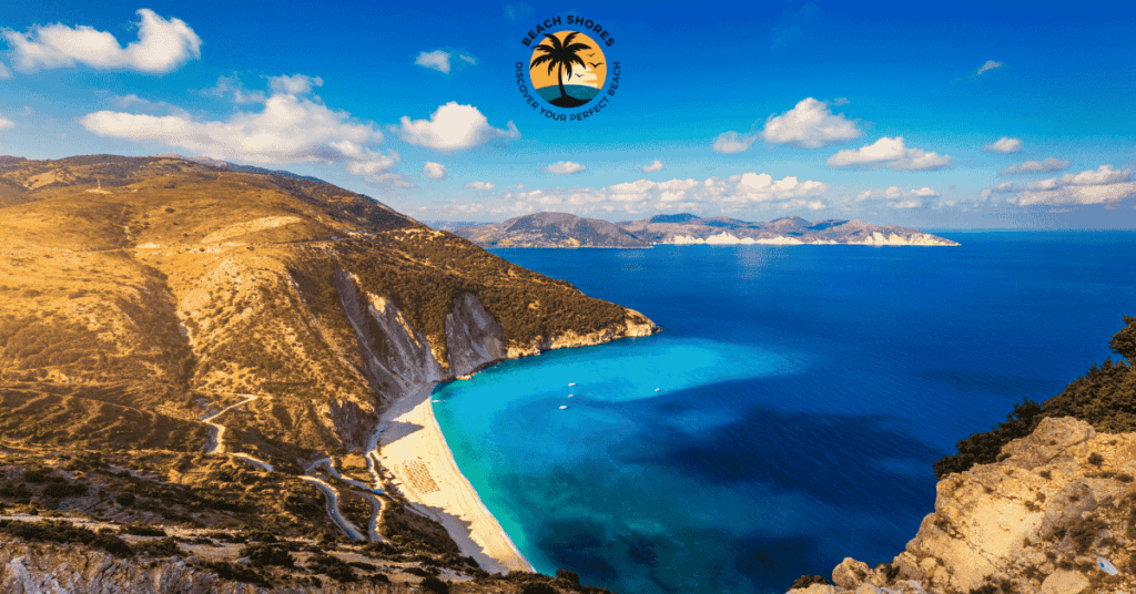 a beach with blue water and mountains