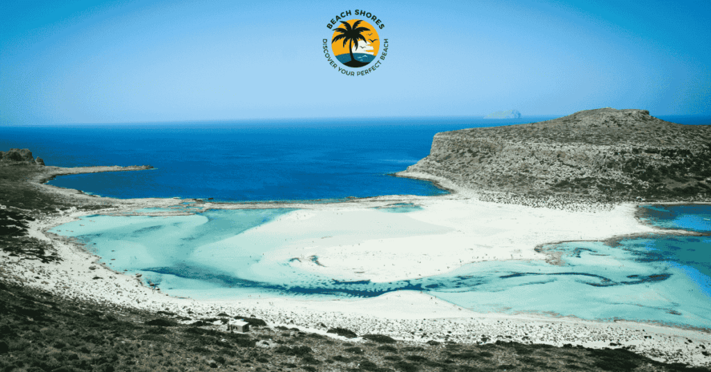 a beach with blue water and rocks